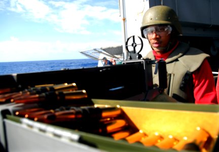 US Navy 090123-N-6597H-156 Aviation Ordnanceman Airman Jonathan Thomas, from Lamar, S.C., prepares to fire a .50-caliber machine gun from the fantail of the aircraft carrier USS John C. Stennis (CVN 74) photo