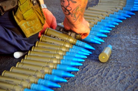 US Navy 090129-N-4774B-008 Gunner's Mate 2nd Class Nicholas Brassard inspects rounds for the MK-38 25mm machine gun system