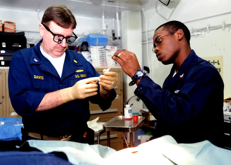 US Navy 090129-N-8822R-026 Hospital Corpsman 3rd Class Robert Davis, right, assists ship's surgeon Capt. Thomas Davis as he prepares an anesthetic before performing a surgery aboard the aircraft carrier USS Theodore Roosevelt (