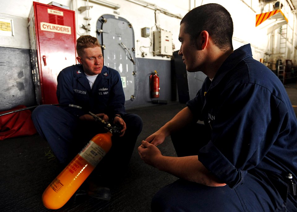 US Navy 090128-N-2908M-001 Damage Controlman 3rd Class Douglas Petersen and Damage Controlman Fireman Andrew Hainan recharge a self-contained breathing apparatus aboard the aircraft carrier USS Theodore Roosevelt (CVN 71)