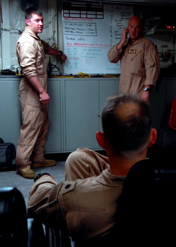 US Navy 090124-N-6278K-009 Naval Air Crewman 2nd Class Brandon Steiner, left, and Chief Naval Air Crewman Brantley Lowe hold a pre-flight briefing aboard the amphibious transport dock ship USS San Antonio (LPD) 17