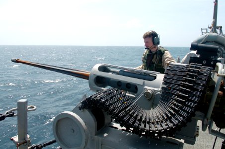 US Navy 090125-N-3931M-124 Information Systems Technician 3rd Class Adam Gayner mans a 25MM chain gun aboard the guided-missile destroyer USS Mason (DDG 87) while monitoring a small boat transiting from the merchant vessel MV F photo