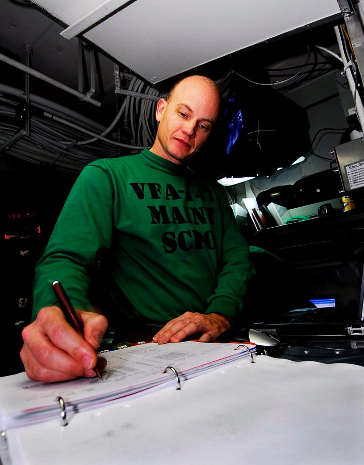 US Navy 090126-N-6538W-072 Senior Chief Aviation Electronics Technician Robert Armer, from New Orleans, verifies maintenance reports from the