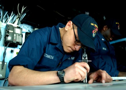 US Navy 090129-N-9520G-010 Quartermaster Seaman Ignacio Castaneda, from Salt Lake City, Utah assigned to the amphibious assault ship USS Essex (LHD 2), plots course changes while standing bridge watch