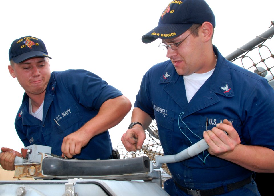 US Navy 090128-N-3666S-006 Gunner's Mate 2nd Class Dieter Chapman and Fire Controlman 3rd Class Brad Campbell perform routine maintenance on a MK-38 25mm machine gun