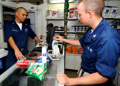 US Navy 090201-N-1082Z-005 Ship's Serviceman 3rd Class Romulo Casavilca monitors a transaction as Fire Controlman 3rd Class Terrence Martinez uses his Navy Cash card in the ship's store