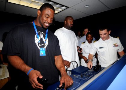 US Navy 090204-N-9758L-030 ) National Football League Pro Bowl players New York Giants Justin Tuck, left, and Tennessee Titans Albert Haynesworth man the lee helm and helmsman positions photo