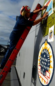 US Navy 090202-N-1688B-065 Aviation Boatswain's Mate Handling 3rd Class Juan Garza finishes a mural for Africa Partnership Station 2009 aboard USS Nashville (LPD 13) photo