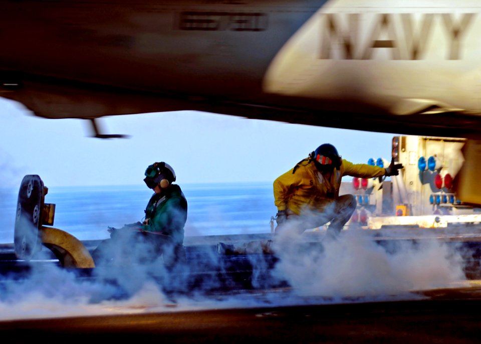 US Navy 090131-N-7571S-005 Lt. Cmdr. Pomponio, right, signals an aircraft to launch from the aircraft carrier USS Theodore Roosevelt (CVN 71)