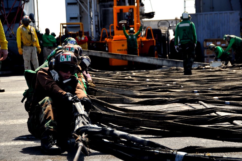 US Navy 111022-N-VD490-008 Air department Sailors pull out the barricade webbing assembly during flight deck drills aboard the aircraft carrier USS