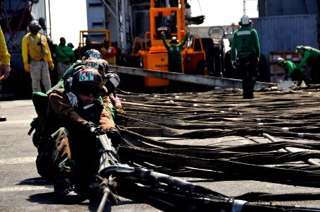 US Navy 111022-N-VD490-008 Air department Sailors pull out the barricade webbing assembly during flight deck drills aboard the aircraft carrier USS