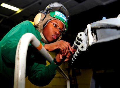 US Navy 090129-N-8822R-004 Aviation Structural Mechanic 3rd Class Alexis Lowe removes sealant from a wing fold transmission on an F-A-18 Super Hornet