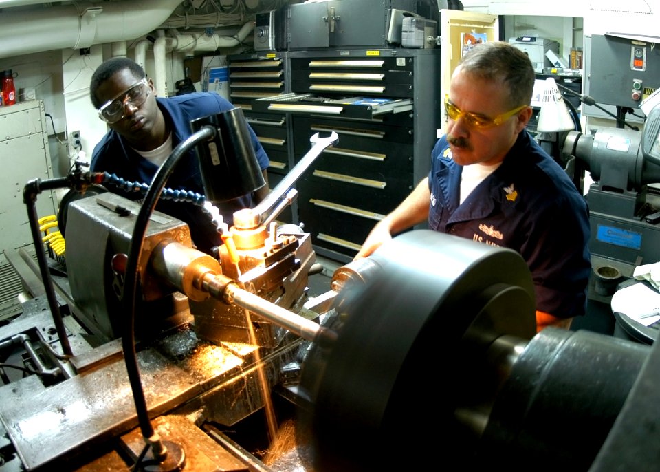 US Navy 090203-N-2636M-054 Machinery Repairman 1st Class Ruben Arocho and Machinery Repairman Fireman Anthony Harris manufacture a shaft on a lathe
