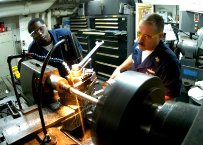 US Navy 090203-N-2636M-054 Machinery Repairman 1st Class Ruben Arocho and Machinery Repairman Fireman Anthony Harris manufacture a shaft on a lathe photo