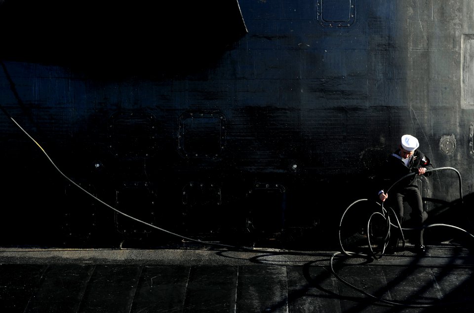 US Navy 090204-N-8467N-005 Electronics Technician 3rd Class Grant Peterson works to untangle the shore phone cable