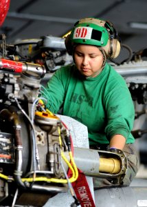 US Navy 090204-N-2562S-003 Aviation Machinist's Mate 1st Class Sandra Lay helps guide a hydro mechanical unit of an HH60-H Sea Hawk