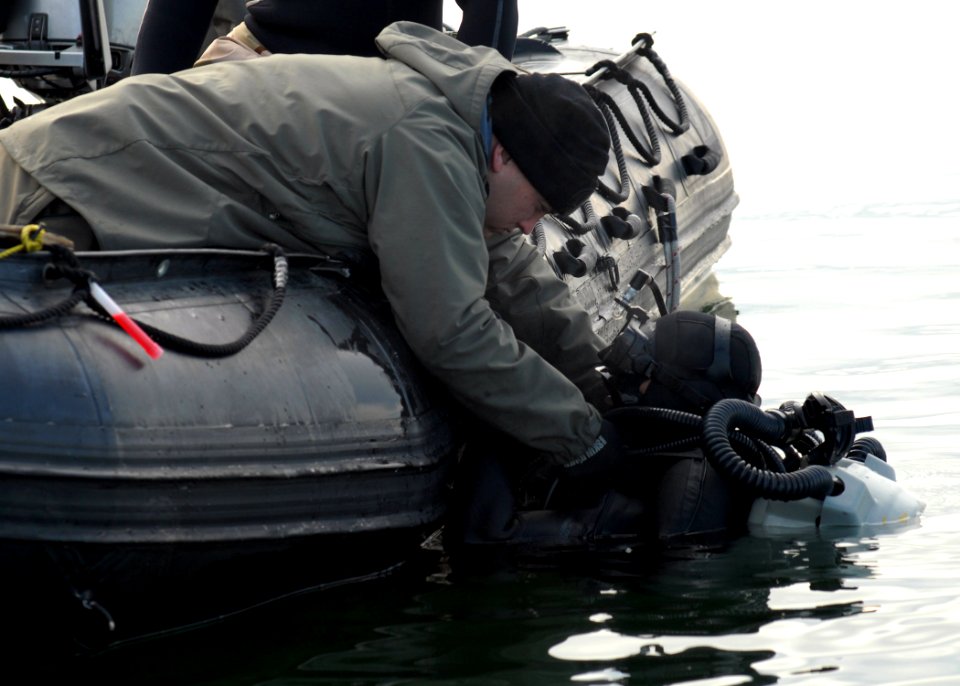 US Navy 090204-N-9860Y-003 Hospital Corpsman 2nd Class (DV) John Dawson reaches to assist Explosive Ordnance Disposal Technician 2nd Class Aaron Casarez