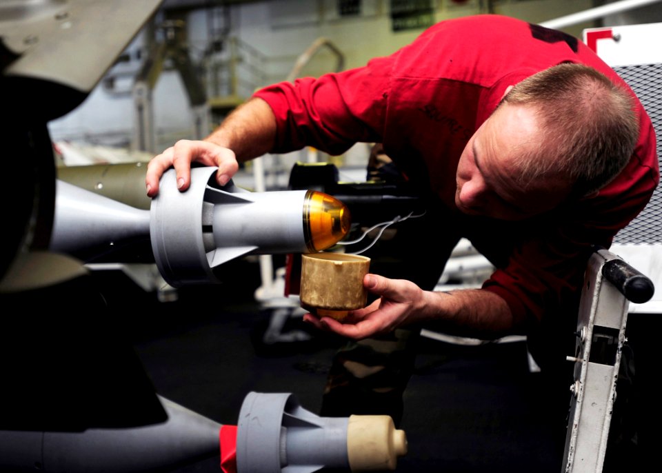 US Navy 090205-N-8822R-048 Aviation Ordnanceman 3rd Class Matthew Squires checks for scratches or debris on the seeker head of a GBU-12 Paveway II laser-guided bomb
