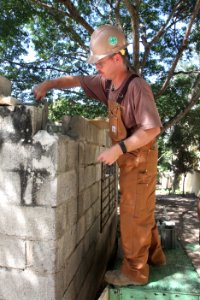 US Navy 111116-A-IP644-181 A Sailor attached to Navy Moblie Construction Battalion (NMCB) 23 cements a brick wall around a generator