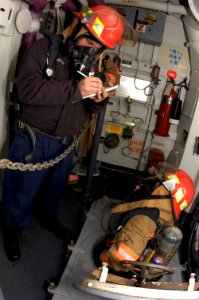 US Navy 090205-N-2636M-034 Aviation Electronics Technician 3rd Class Ryan Butler, from New Orleans, records information to relay to his repair locker during a damage control drill aboard the multi-purpose amphibious assault shi