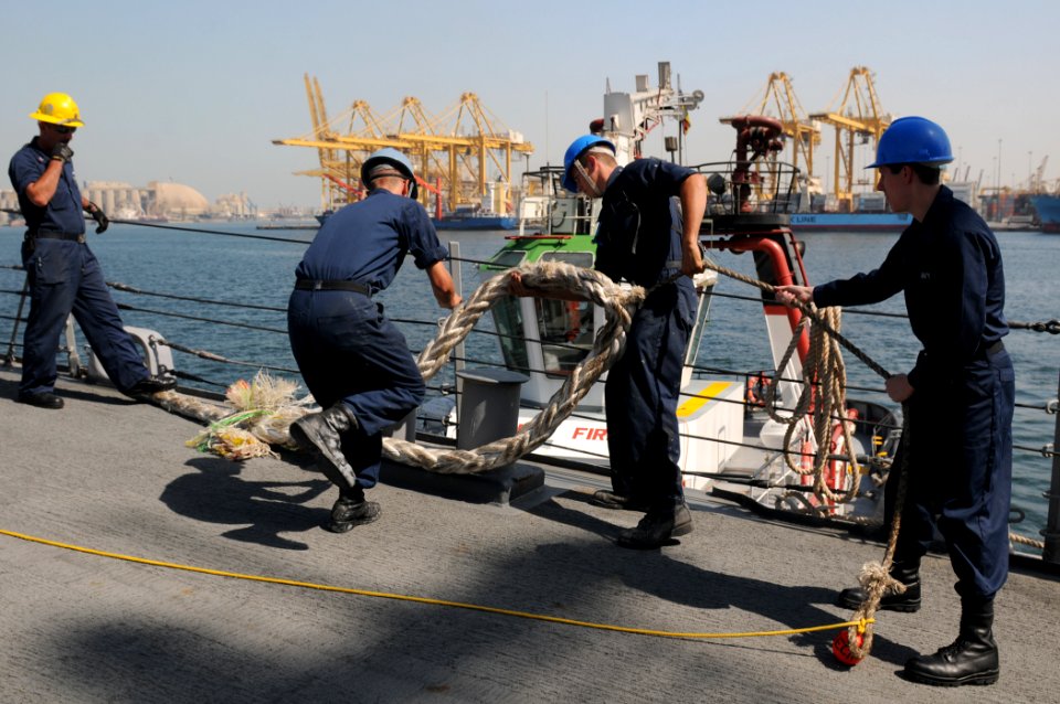 US Navy 111028-N-XQ375-016 Boatswain's Mate 1st Class Dave Mullins, left, observes as Seamen Daniel Nogal, Robert Reynolds and Justin Luther heave