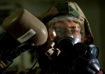 US Navy 111212-N-DR144-296 Yeoman 3rd Class Andrew Velasquez drinks from a canteen while wearing an MCU-2P protective mask