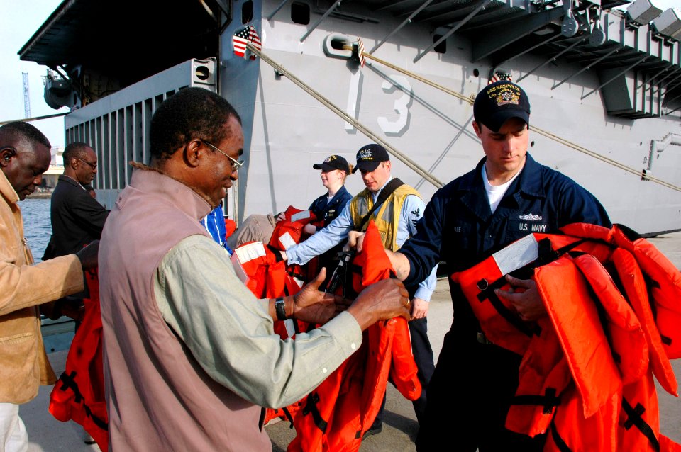 US Navy 090206-N-1655H-705 Sailors assigned to the amphibious transport dock USS Nashville (LPD 13) pass out life vests to Senegalese marine biologists before boarding a rigid hull inflatable boat