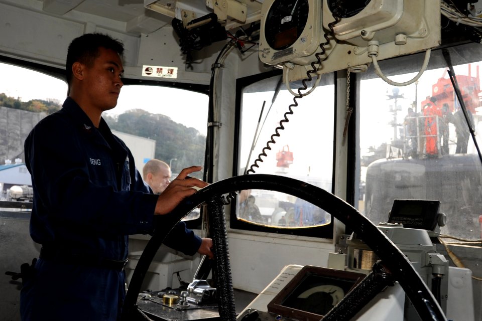 US Navy 111221-N-DI599-050 A Sailor pilots a tug that maneuvers the USS North Carolina
