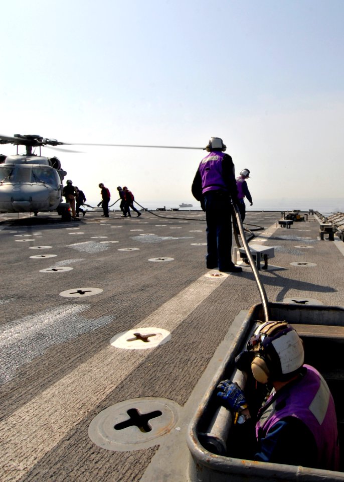 US Navy 090209-N-3392P-045 Sailors aboard the amphibious dock landing ship USS Carter Hall (LSD 50) fuel an MH-60S Sea Hawk Helicopter from Helicopter Sea Combat Squadron (HSC) 26