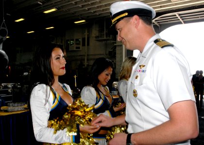 US Navy 090206-N-8283S-185 Capt. Frank Michael, executive officer of the amphibious assault ship USS Boxer (LHD 4), presents a command coin to each member of the San Diego Chargers cheerleaders during their visit aboard Boxer