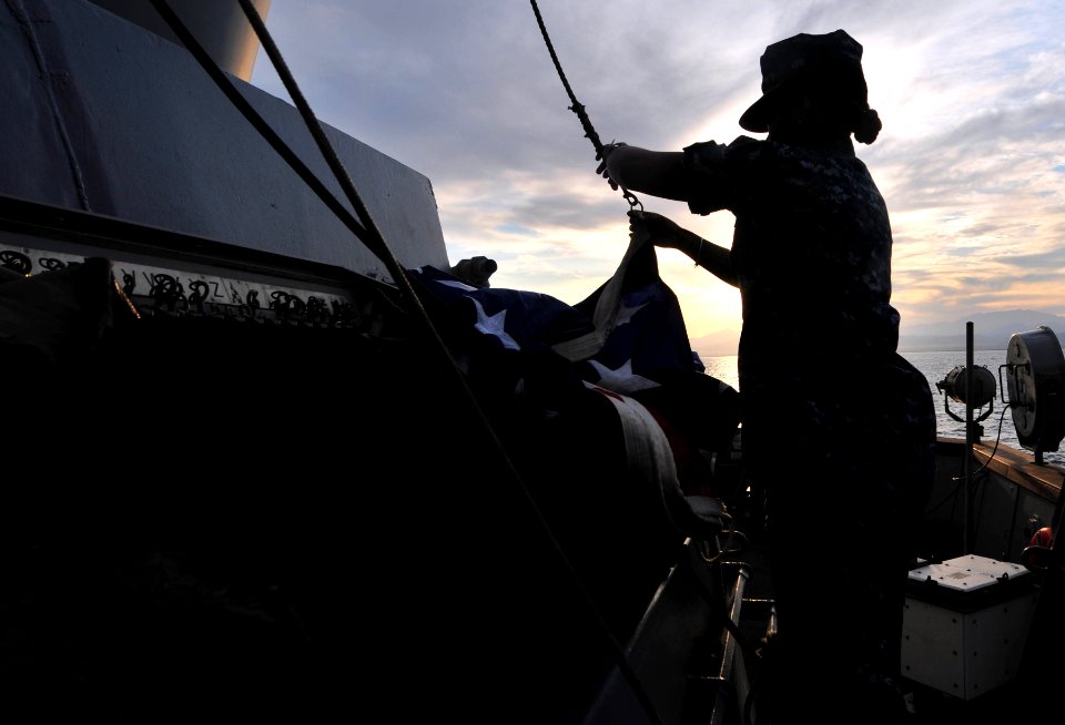 US Navy 111231-N-CT127-060 Quartermaster 3rd Class Marshe McNeal prepares to hoist the American flag aboard the San Antonio-class amphibious transp