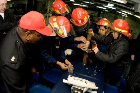 US Navy 090205-N-2636M-049 Sailors assigned to the multi-purpose amphibious assault ship USS Bataan (LHD 5) conduct training on pipe-patching techniques during a general quarters drill