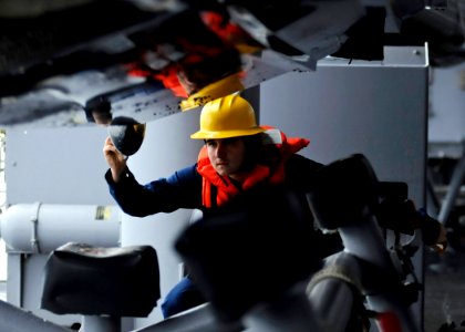 US Navy 090209-N-7280V-098 Boatswain's Mate 3rd Class Michael Jimenez directs a davit operator to seat a rigid hull inflatable boat after a practice underway man overboard recovery drill aboard the amphibious command ship USS B