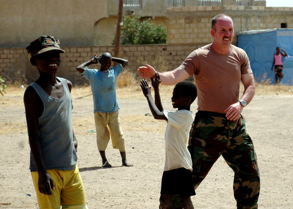 US Navy 090207-N-1655H-287 A service member from the U.S. Embassy in Dakar, Senegal, gives a high-five to a Senegalese boy while playing soccer at the Vivre Ensemble orphanage after a team of Africa Partnership Station 2009 mem