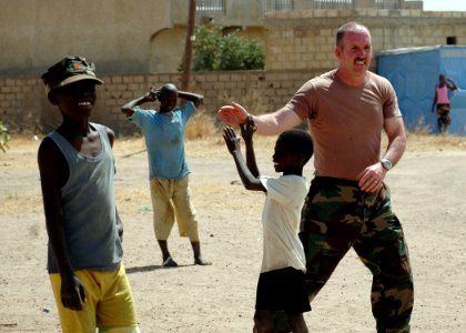 US Navy 090207-N-1655H-287 A service member from the U.S. Embassy in Dakar, Senegal, gives a high-five to a Senegalese boy while playing soccer at the Vivre Ensemble orphanage after a team of Africa Partnership Station 2009 mem photo