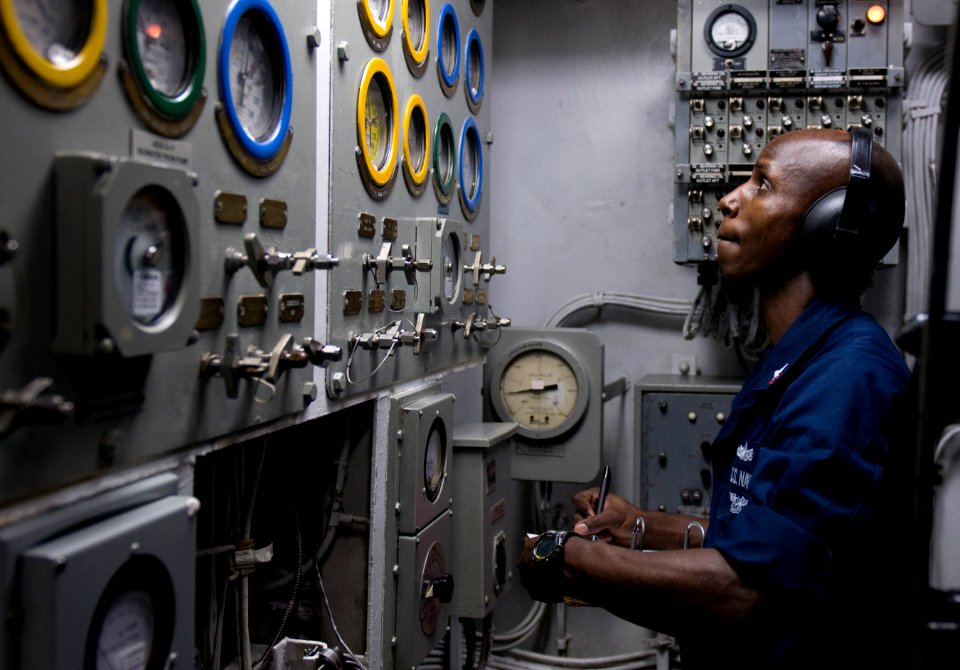 US Navy 120110-N-TZ605-186 Machinist's Mate 2nd Class Demale Crews charts gauge readings in an emergency diesel generator space