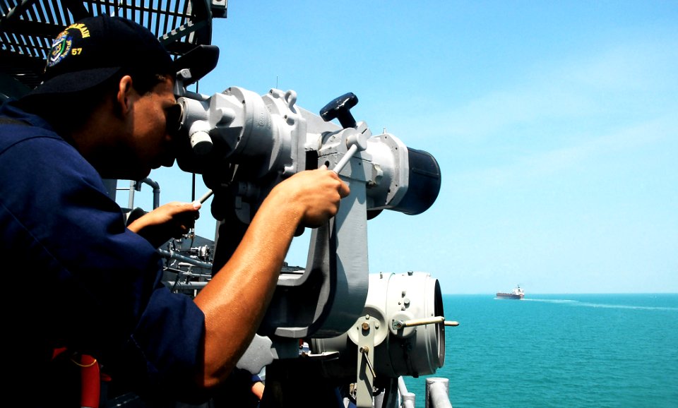 US Navy 090210-N-4774B-105 Seaman Anthony Brown observes boat traffic using ship-mounted binoculars aboard the guided-missile cruiser USS Lake Champlain (CG 57)