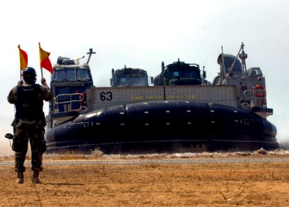 US Navy 090207-N-5253W-045 Seaman Christopher Smith directs Landing Craft Air Cushion 63 as it transports Marines and equipment ashore for Cobra Gold 2009 photo