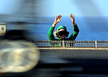 US Navy 090210-N-7571S-011 Aviation Boatswain's Mate (Equipment) 3rd Class Nancy Germann clears her hands from the catapult release button after she releases an aircraft during the first event of flight operations aboard the ai