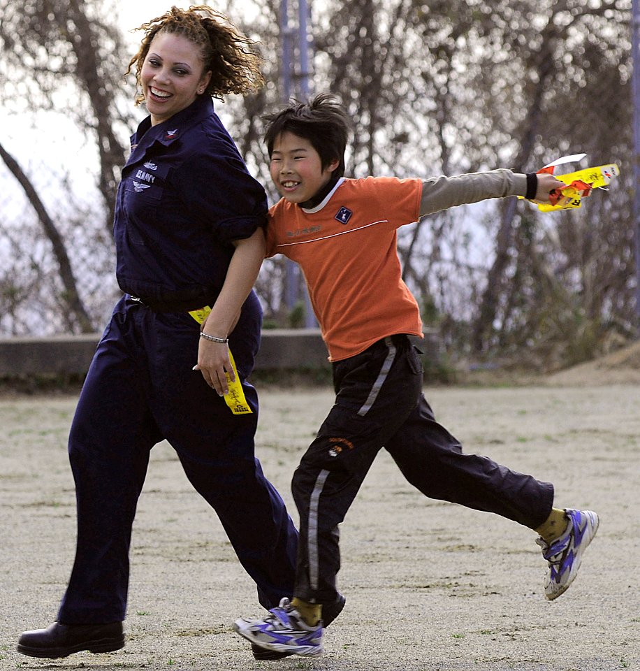 US Navy 090207-N-8546L-441 Operations Specialist 2nd Class Iesja Aldridge plays tag with a child from the Myojoo-en Children's Home