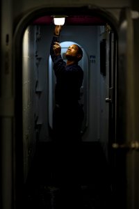 US Navy 120130-N-XE109-018 A Sailor performs maintenance on a light fixture