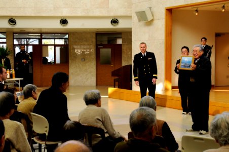 US Navy 090207-N-3830J-059 Izumi Ikeha, board director of the Nozomi No Mori Senior Citizens Home, receives a plaque from Lt. Steven T. Benefield, chaplain of the amphibious command ship USS Blue Ridge (LCC 19), during a commun