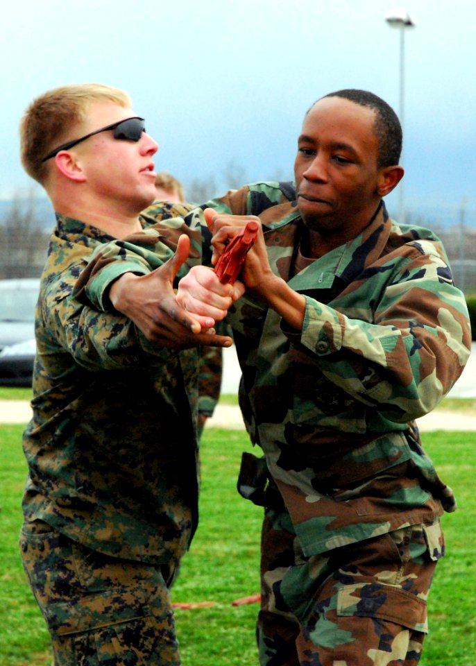 US Navy 090212-N-4044H-059 Master-at Arms Seaman Martavius Eackles, assigned to Naval Support Activity Naples, performs a basic weapons takeaway maneuver on Marine Corps Sgt. Albert Tippett