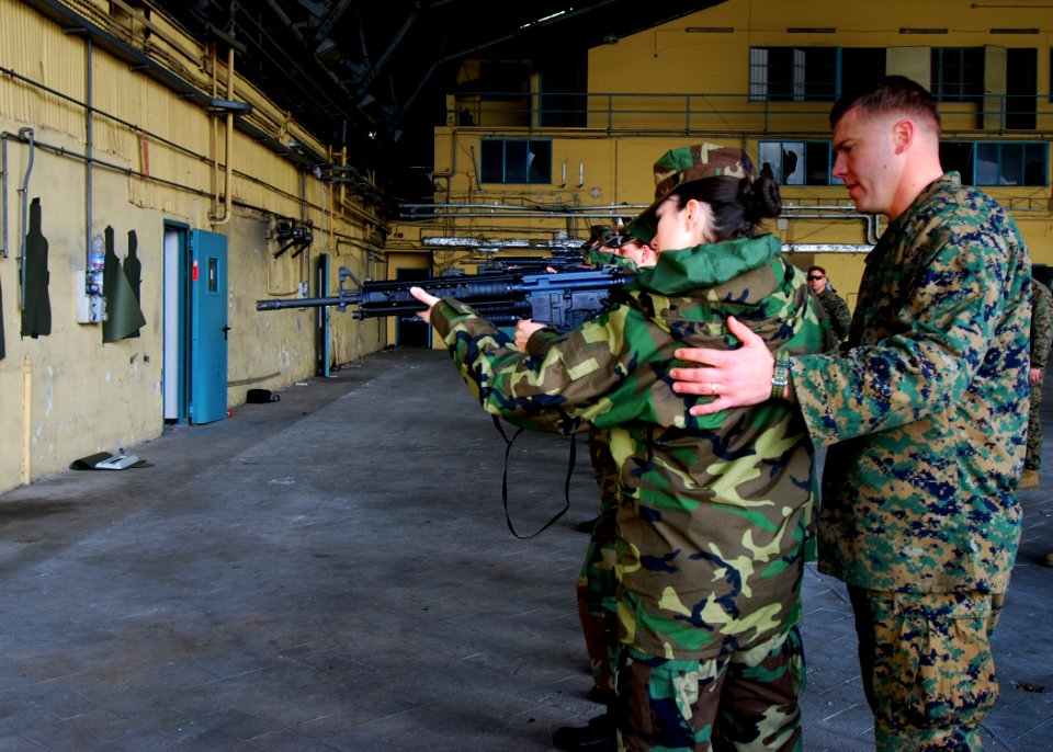 US Navy 090211-N-4044H-004 Sgt. Harold Finley, assigned to 2nd Platoon, Fleet Antiterrorism Security Team (FAST), Company Europe, positions Master-at- Arms Seaman Kristin Sullivan into a more effective shooting stance
