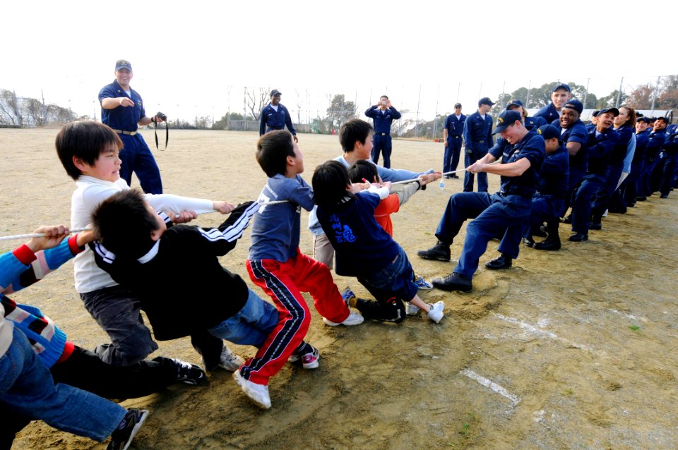 US Navy 090207-N-8546L-744 Sailors assigned to the amphibious command ship USS Blue Ridge (LCC 19) and embarked U.S. 7th Fleet staff Sailors play tug-of-war with orphans from the Myojoo-en Children's Home during a community out