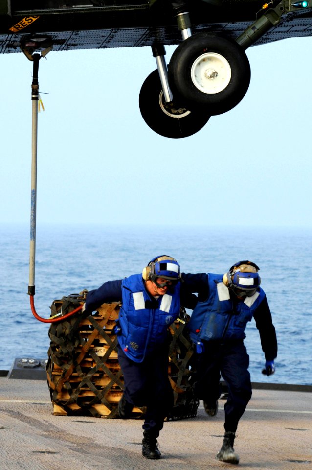 US Navy 090210-N-3830J-239 Boatswain's Mate 3rd Class Raphael Zakar and Seaman Jeremiah L. Chillis run clear from an SH-60F Sea Hawk helicopter after attaching cargo aboard the amphibious command ship USS Blue Ridge (LCC 19)