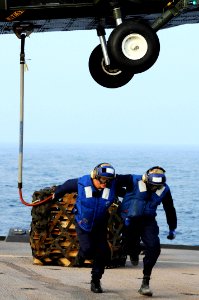US Navy 090210-N-3830J-239 Boatswain's Mate 3rd Class Raphael Zakar and Seaman Jeremiah L. Chillis run clear from an SH-60F Sea Hawk helicopter after attaching cargo aboard the amphibious command ship USS Blue Ridge (LCC 19)