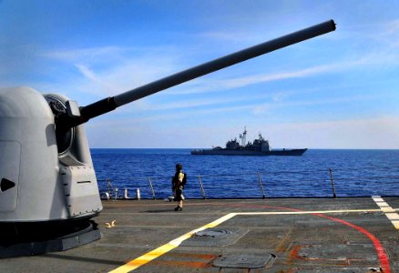 US Navy 090213-N-4774B-098 A member of a visit, board, search and seizure team stands lookout watch by a MK-45 5-inch-54-caliber gun aboard the guided-missile destroyer USS The Sullivans (DDG 68)