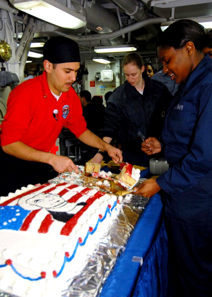 US Navy 090213-N-6233C-028 Culinary Specialist 3rd Class Paul Valdez serves birthday cake to Sailors aboard the aircraft carrier USS George Washington (CVN 73)