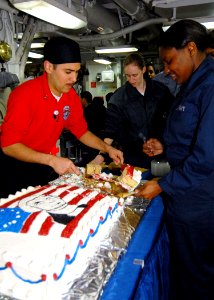 US Navy 090213-N-6233C-028 Culinary Specialist 3rd Class Paul Valdez serves birthday cake to Sailors aboard the aircraft carrier USS George Washington (CVN 73)